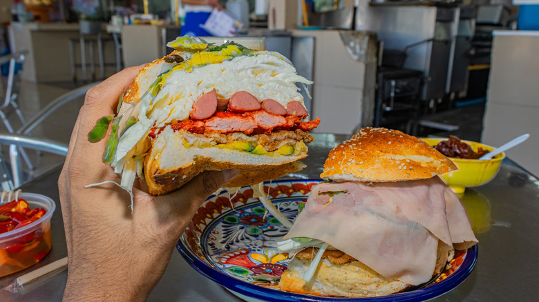 cemita sandwhich held in hand in restaurant