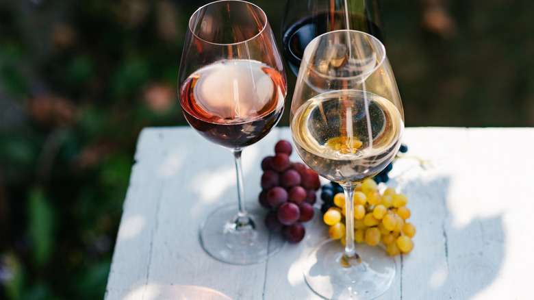 Wine glasses on a white table with grapes