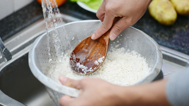 Washing rice in a colander with spoon