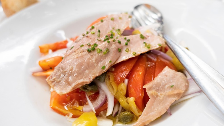 Tuna belly served on top of a salad.