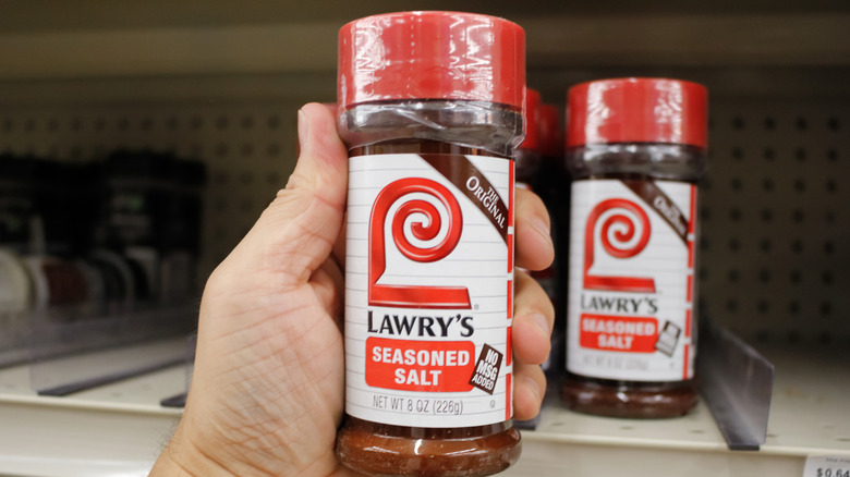 Hand holding a container of Lawry's seasoned salt