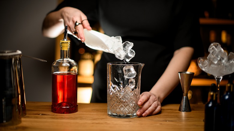 bartender pouring ice into glass