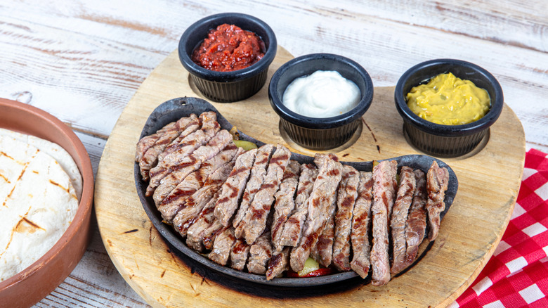 beef fajitas served with sauces and tortillas