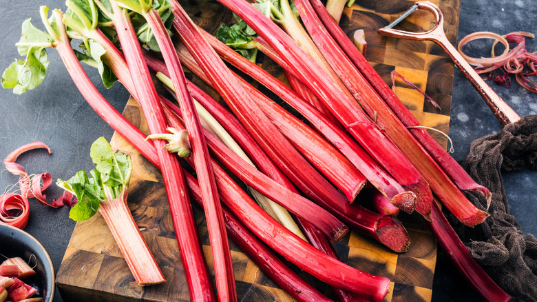 Fresh pink rhubarb stalks on wooden board