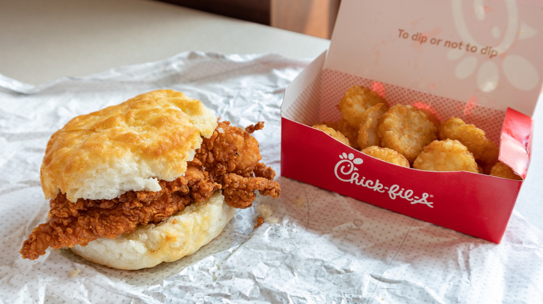 a Chick-fil-A biscuit chicken breakfast sandwich and hashbrowns