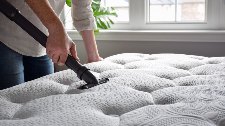 person vacuuming mattress