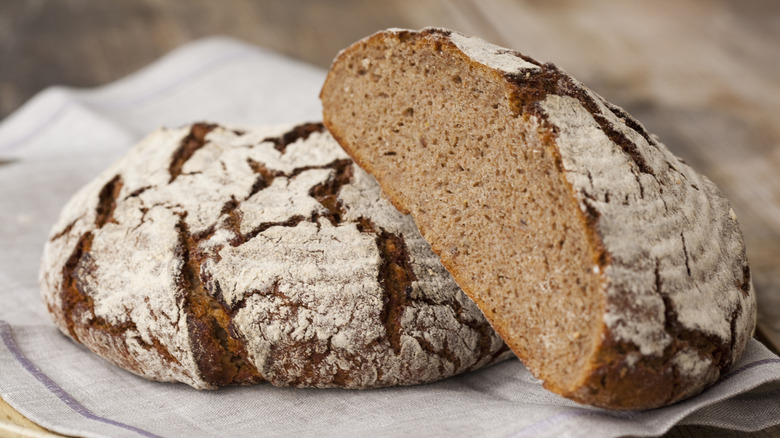 Loaves of floured bread on white towel