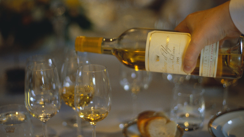 A bottle of Sauternes poured into wine glasses