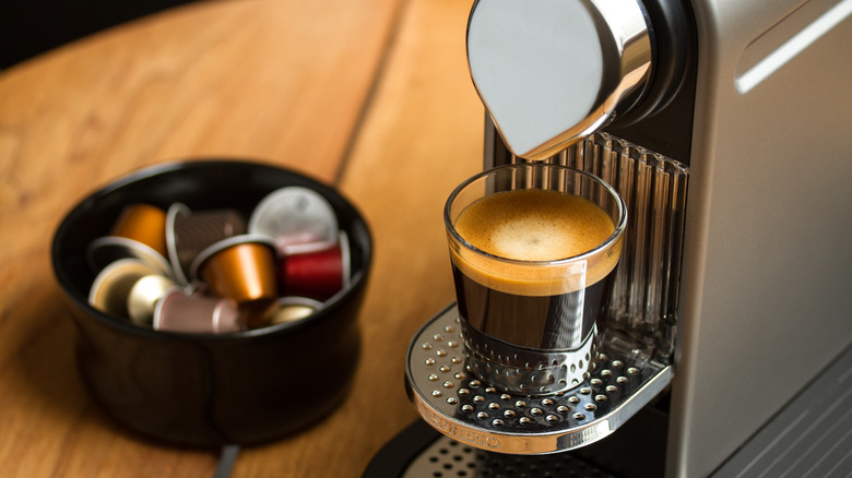 A Nespresso machine with fresh brewed espresso