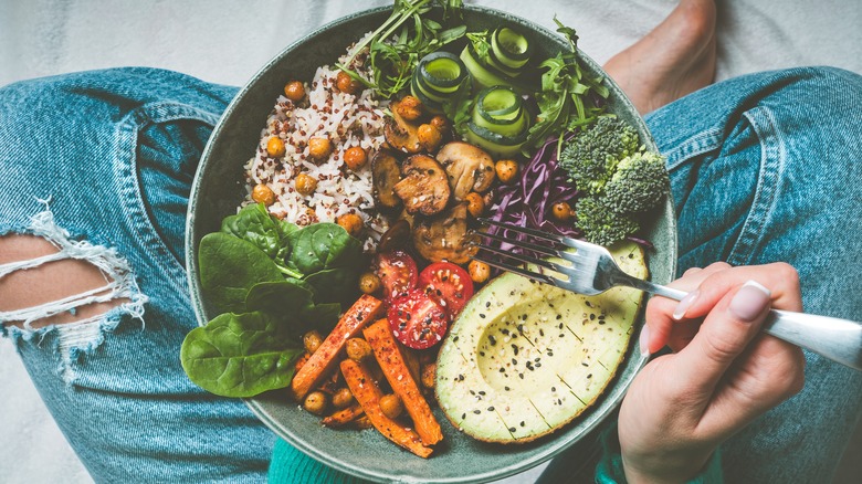 bowl of vegetables in woman's lap