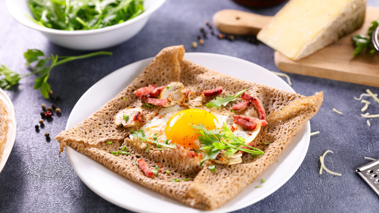 Savory crepe on a dish surrounded by ingredients