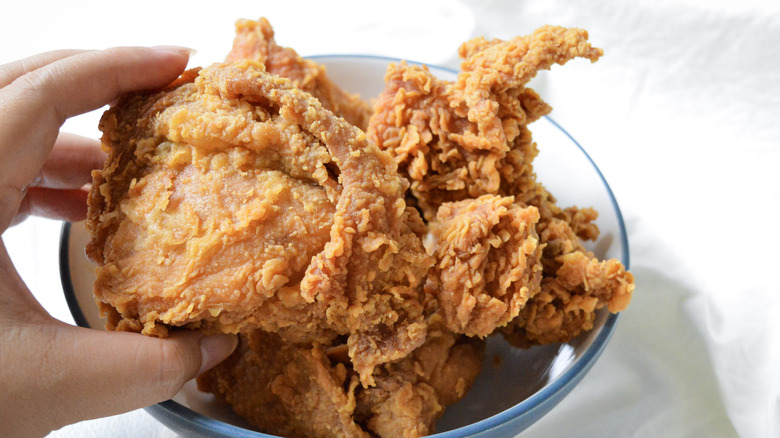 hand grabbing fried chicken