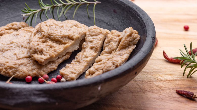 Vital wheat gluten mock meat is arranged in a black bowl.