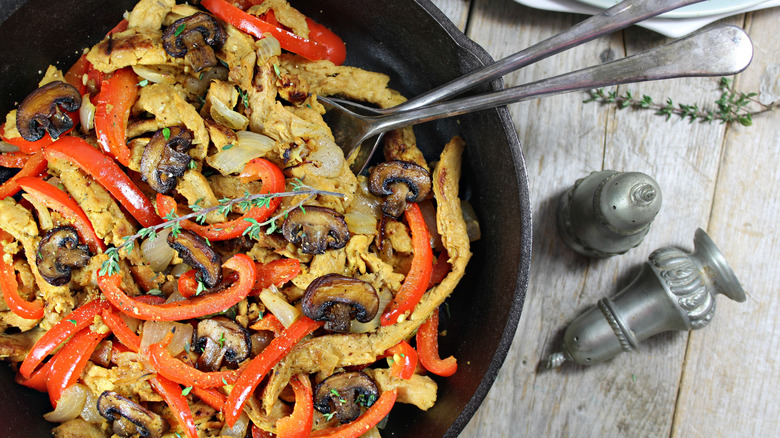 A vegan pan with crushed soy curls lies in a pan with spoons.