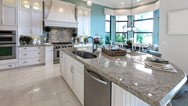 Gray granite kitchen counter in a white and blue kitchen