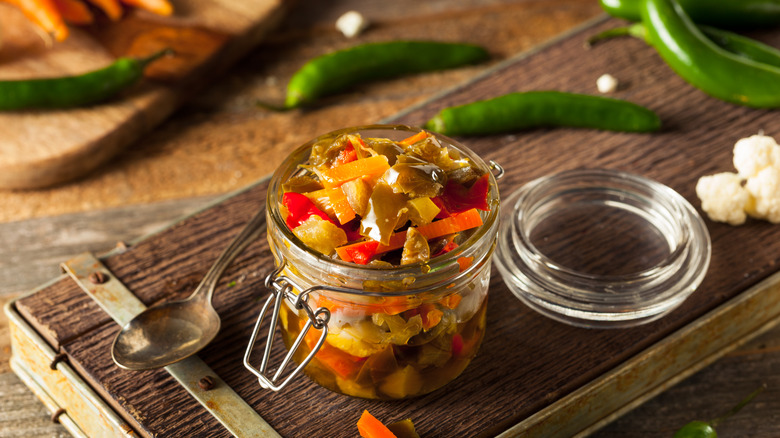 Jar of homemade giardiniera on wood board