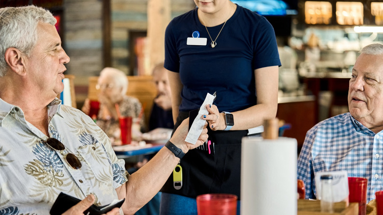 Two senior diners paying the check at a restaurant