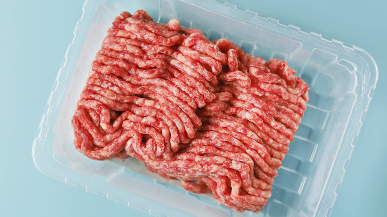 Ground meat sample sits in a plastic container.