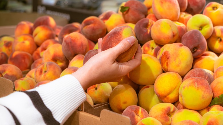 hand holding peach at store