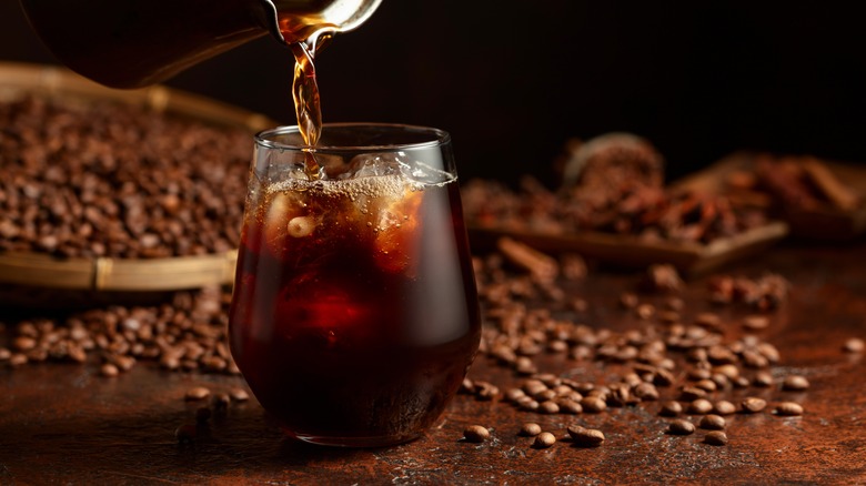 Cold brew coffee surrounded by coffee beans