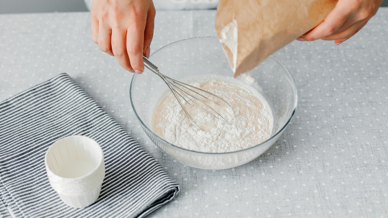 Person pouring flour into a bowl