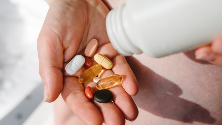 Hand holding supplements and vitamins