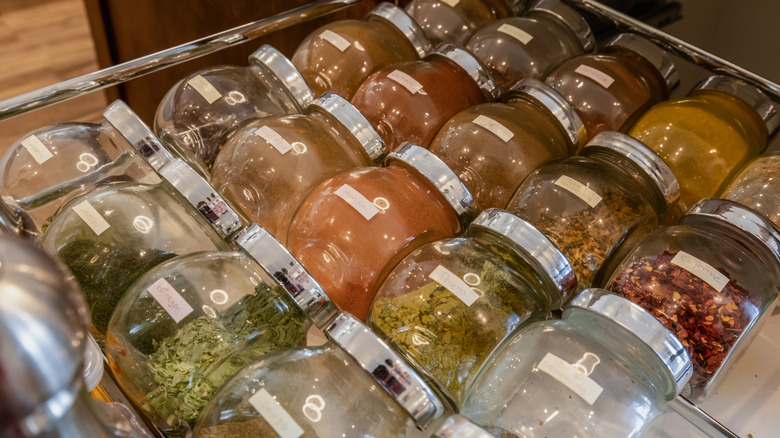 Open drawer with various spices in jars