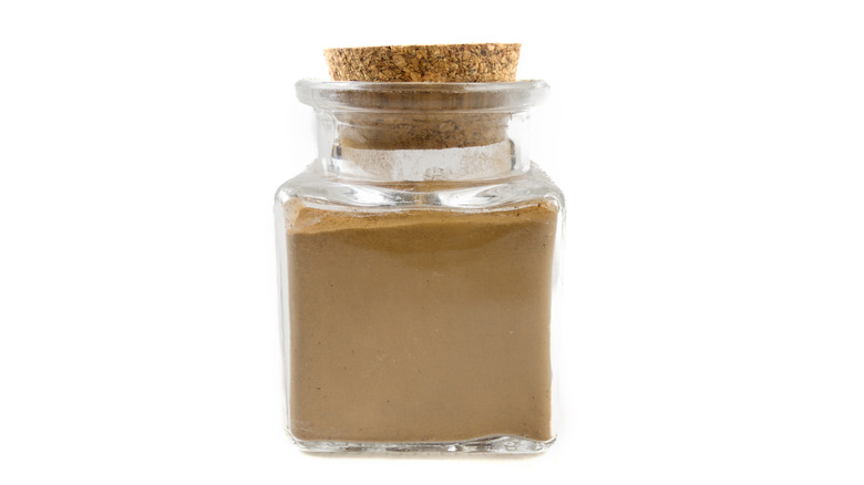 Ground cinnamon in a jar on white background
