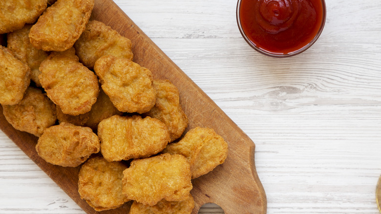 McNuggets on wood board with sauce