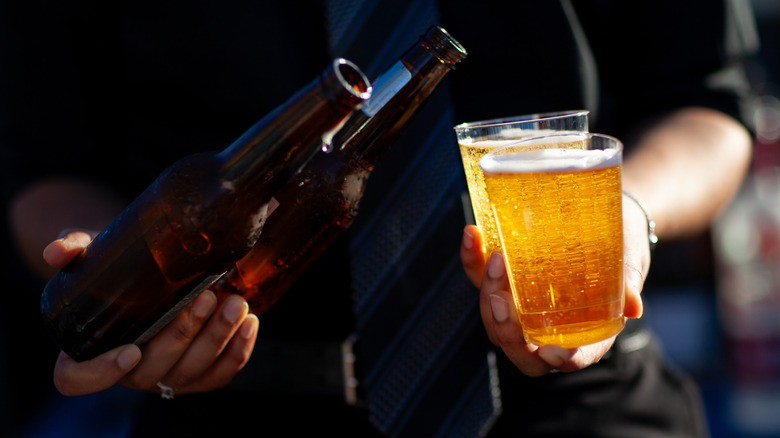 Pouring bottles of beer into two glasses