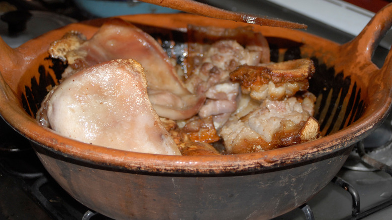 Various pork carnitas parts in a cazuela