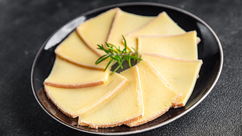 Sliced raclette cheese on a plate.