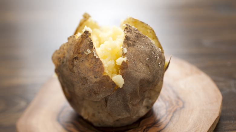 Baked potato on cutting board