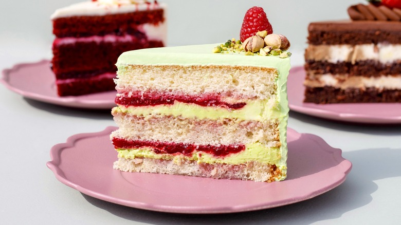 Slices of layer cake on pink plates