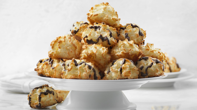 A stack of coconut macaroons on a white platter