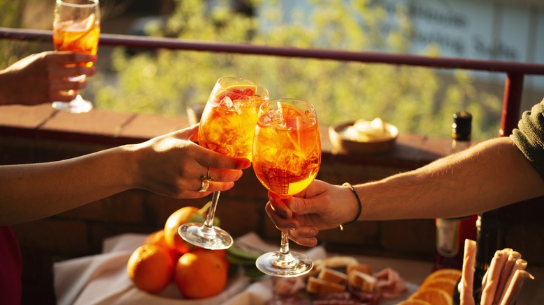 people toasting aperol spritz