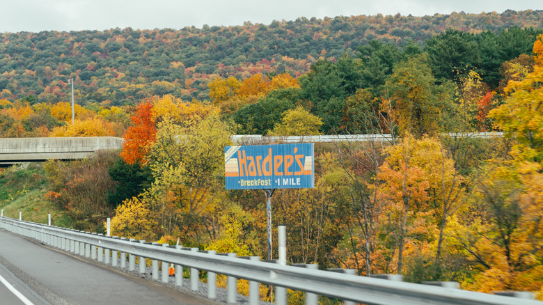 Retro Hardee's breakfast road sign along a highway with fall foliage in Pennsylvania