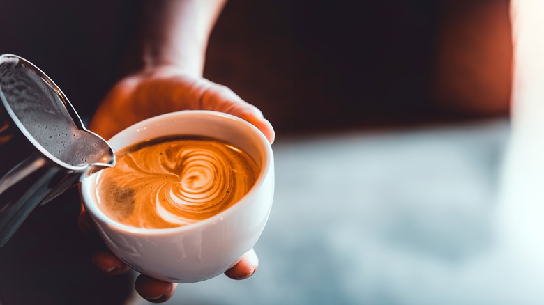 Milk being poured into a latte.