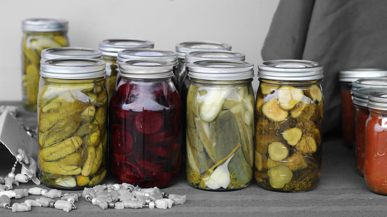 Glass canning jars filled with preserved vegetables.