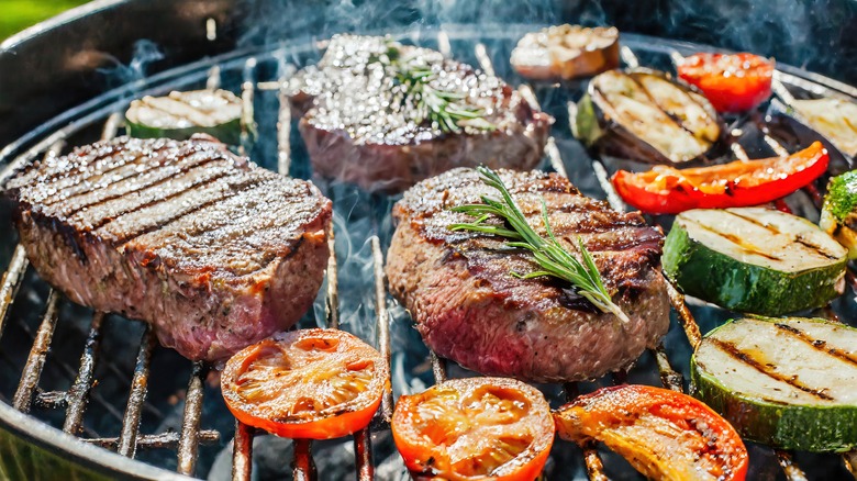 Steak and veggies cooking on a grill