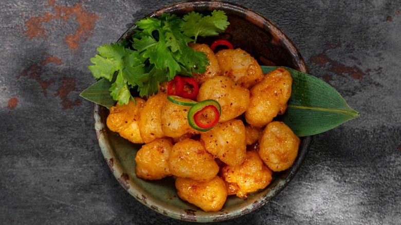 Tempura-fried popcorn shrimp in a bowl with jalepeño, chili peppers, and cilantro