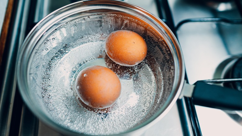 Eggs simmering in a pot of water on the stove