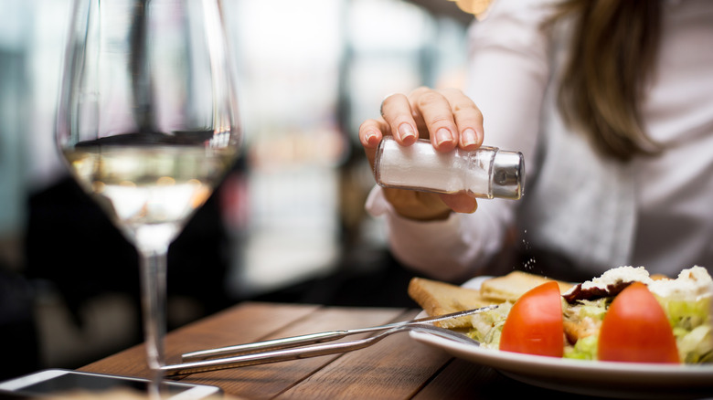 Woman salting her food 