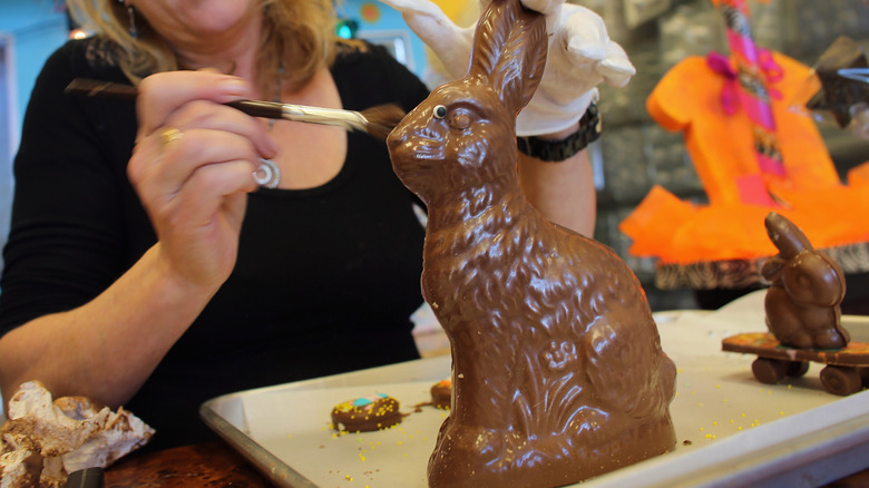 Chocolatier putting finishing touches on a large chocolate Easter bunny