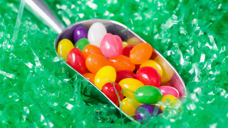 Close-up of. a scoop of multicolored jelly beans on green shredded pastic
