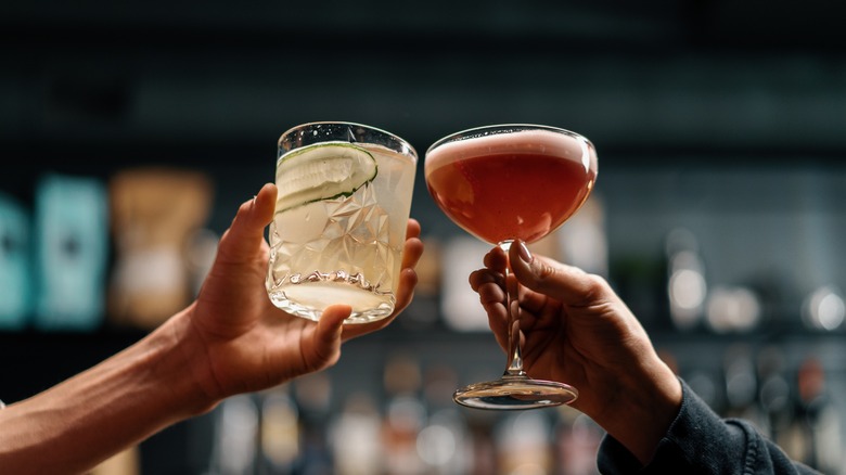 people clinking cocktail glasses