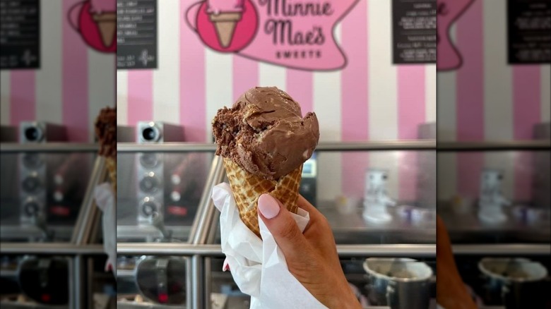 A person holding a chocolate ice cream cone at Minnie Mae's at Graceland