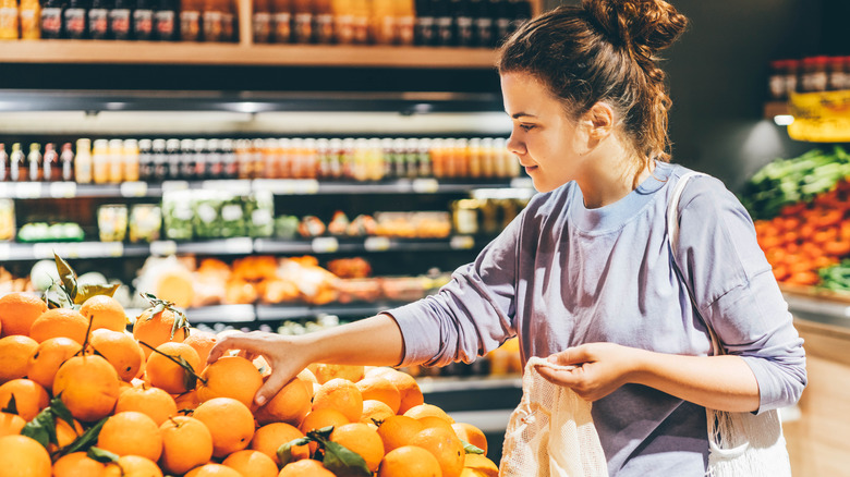 Woman selecting oranges at store