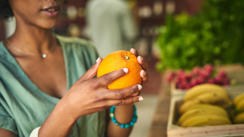 A woman examining an orange