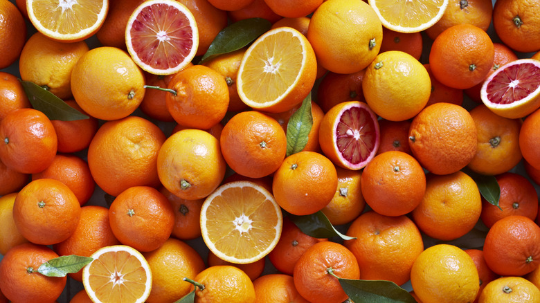 Full and halved fresh oranges